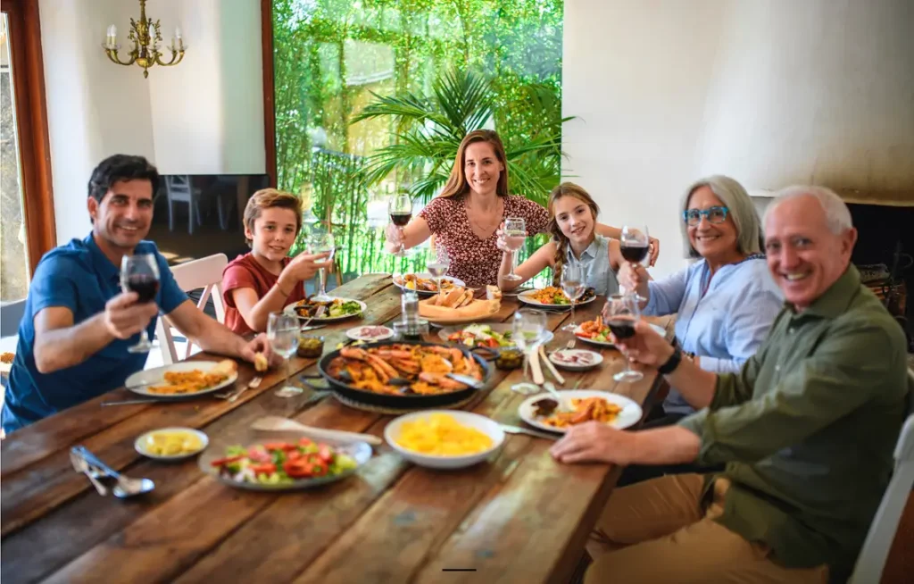 grupo de personas sentadas en una mesa compartiendo una comida juntos